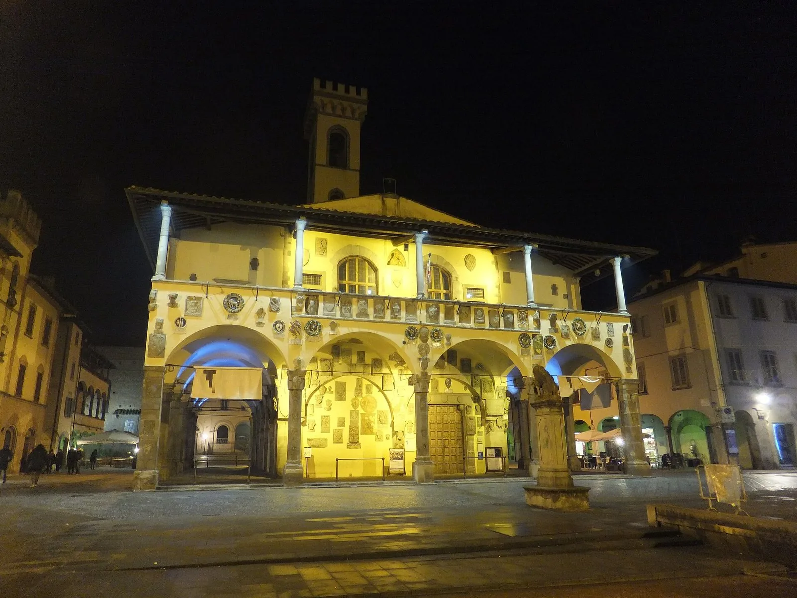 Il Palazzo d'Arnolfo di San Giovanni Valdarno illuminato di notte, con il loggiato e gli stemmi in facciata